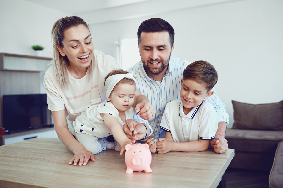 familia ahorra metiendo dinero en una hucha cerdito