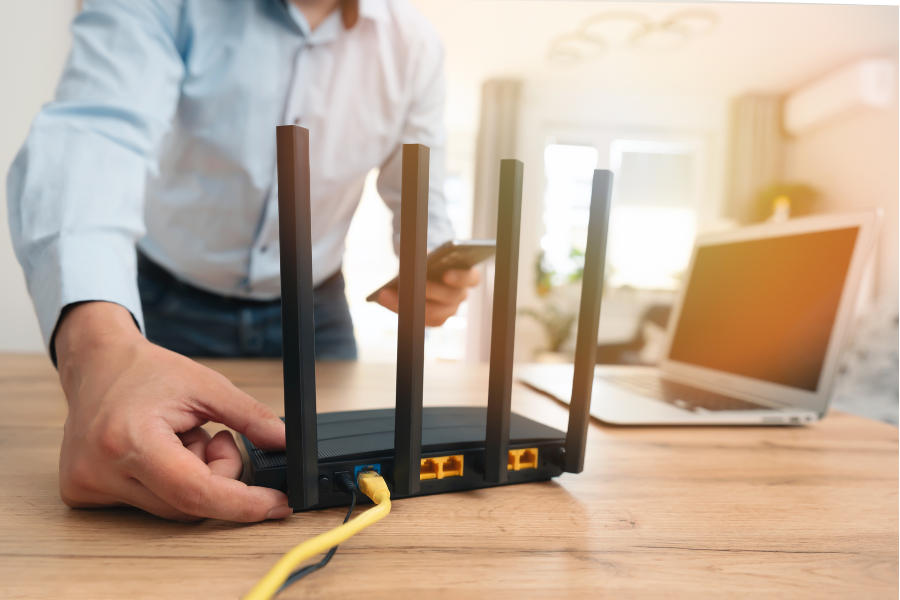 hombre ajustando cables de un router wifi