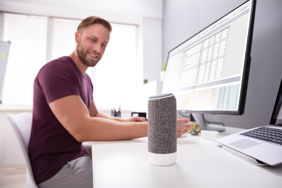 hombre teletrabajando hablando con su asistente de voz google home