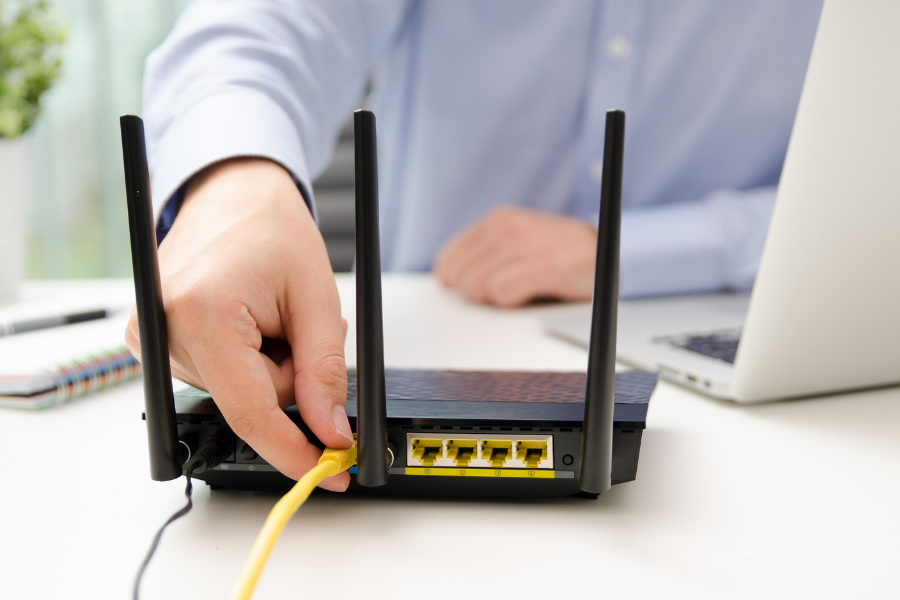 hombre conectando un cable ethernet a un router